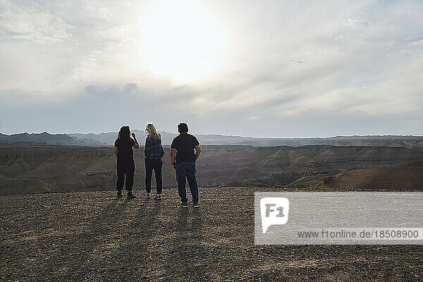 Three people looking to the Grand Canyon from a viewpoint  windy