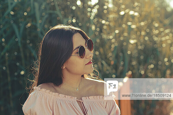 Portrait of a pretty woman wearing sunglasses outdoor in a summer day