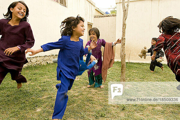 Children laugh and play in the courtyard of their Kabul home.