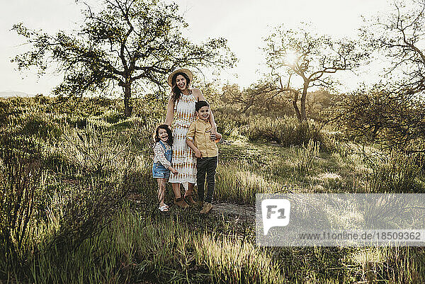 Portrait of beautiful mother and young children in sunny field