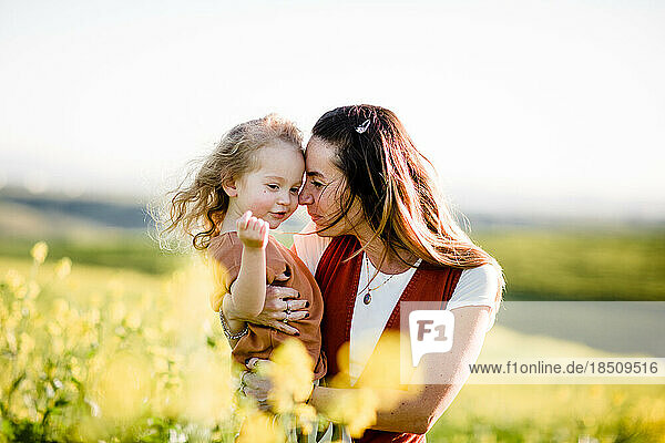 Mom Holding Daughter in Flower Field in San Diego