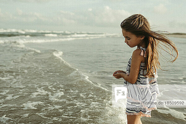 Girl standing in ocean in Corpus Christi Texas with hair blowing