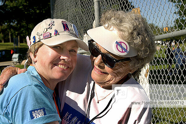 Two women wear buttons at a breast cancer walk in Detroit.