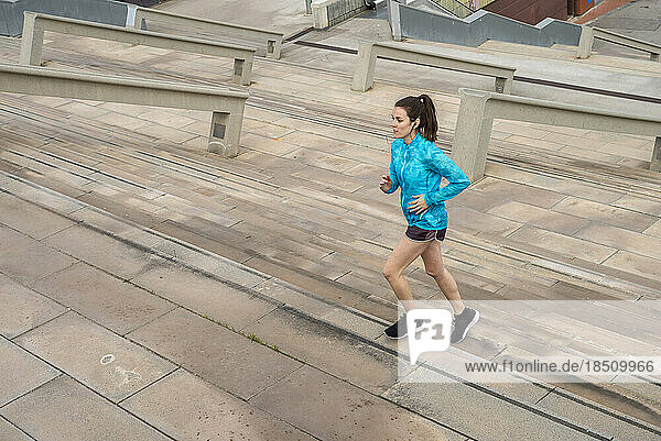 Young runner woman training climbing stairs on the streets of Ba