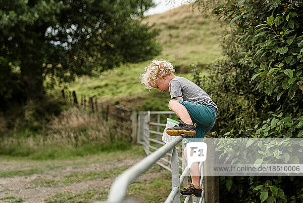 Active independent child climbing over a fence