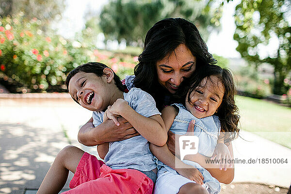 Mom Holding Son & Daughter Hugging & Laughing
