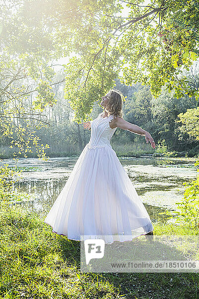 View of a beautiful bride dancing by lake  Germany
