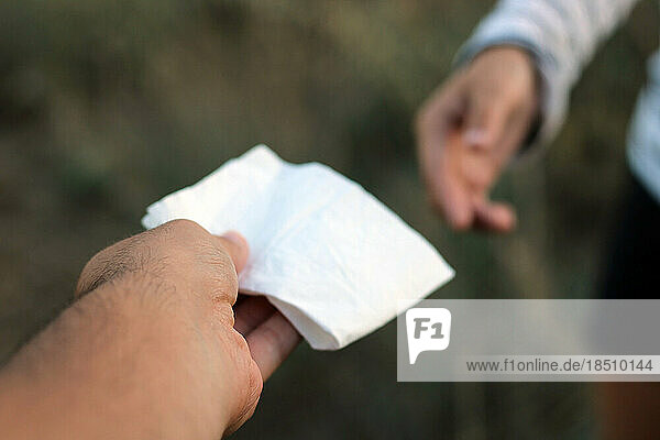 Offering a handkerchief to a woman with a cold.