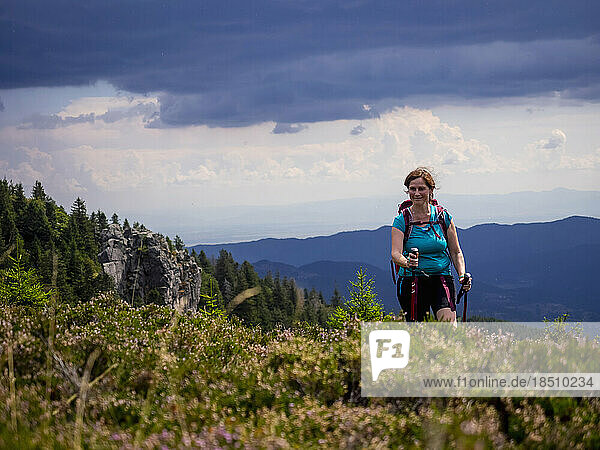 Women hiking on meadow towards valley at Col de la Schlucht In the Vosges  Alsace  France