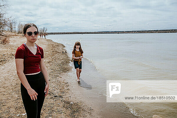 unhappy teen girl standing next to lake