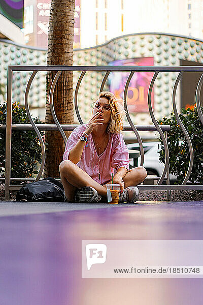 Las Vegas. girl female sits on the sidewalk  smokes  drinks coff