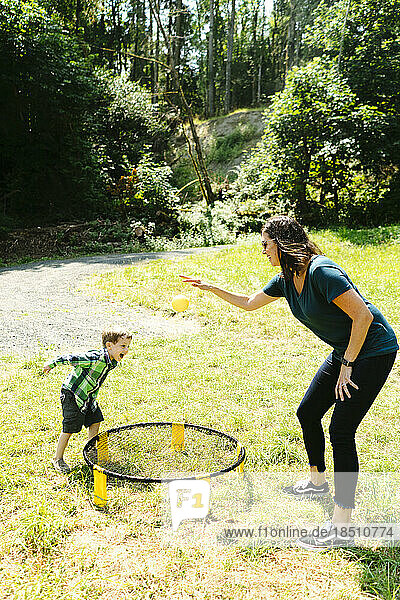 Side view of a woman and a child playing a game while camping