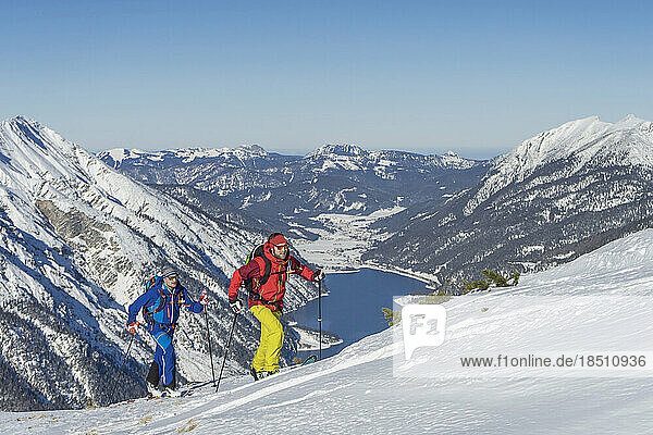 Skiers climbing on snow covered mountain
