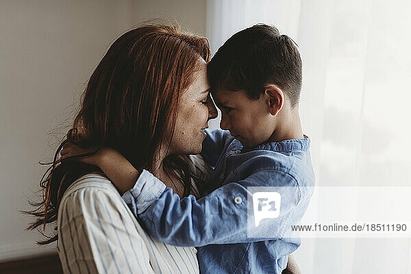 Side view of young mother embracing young boy in studio
