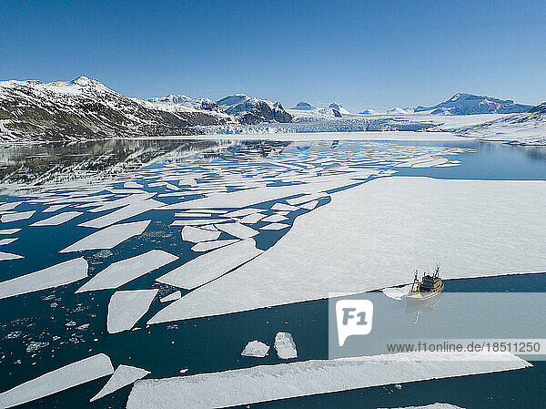 aerial view of pack ice with a boat sailing