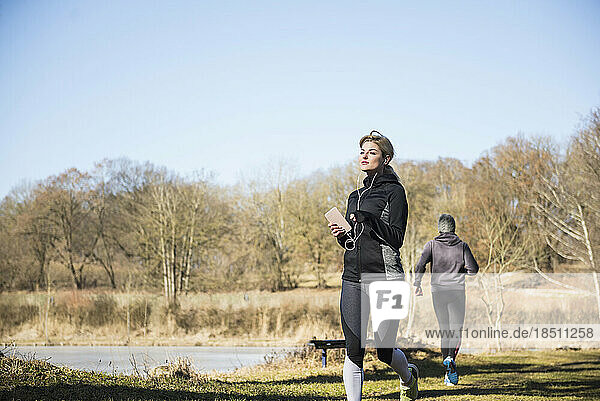 Man and woman jogging on fitness trail in forest