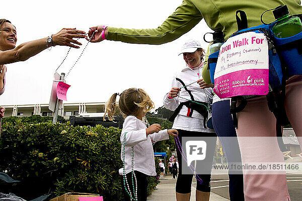 Supporters hand out necklaces to walkers at the Avon Walk for Breast Cancer in San Francisco.