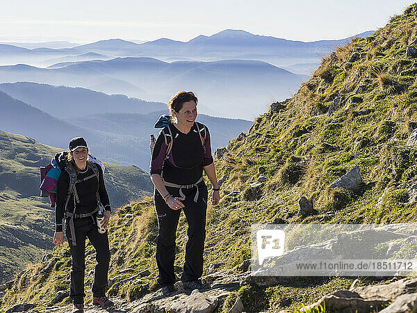 Two women walking towards the top of Txindoki during hiking tour