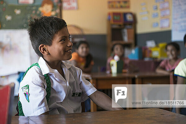 Peruvian boy paying attention to his teacher in the classroom