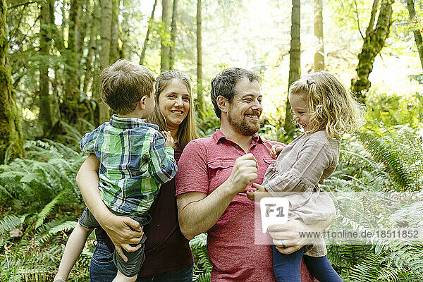 Portrait of a young family of four in the forest