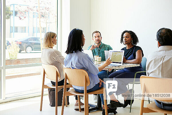 Multiracial colleagues planning strategy while sitting in cafe