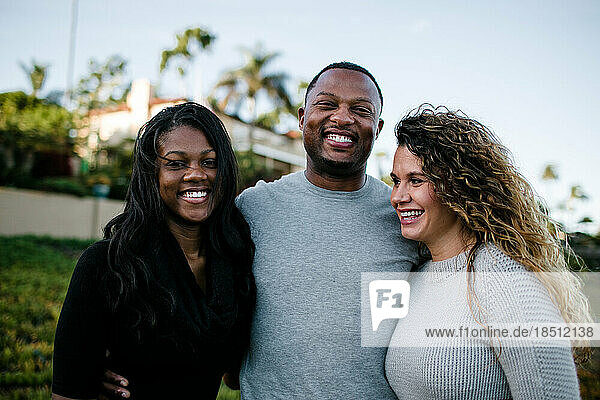Blended family smiles and laughs on beach at sunset