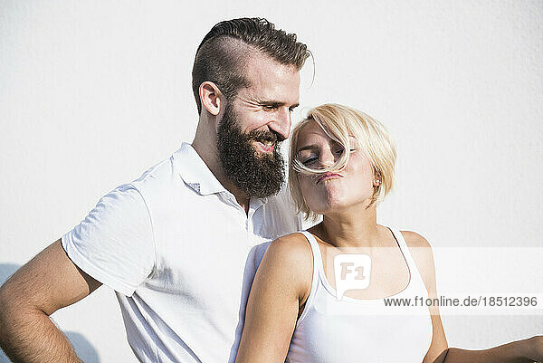 Young man smiling with his playful girlfriend making moustache with hair  Bavaria  Germany