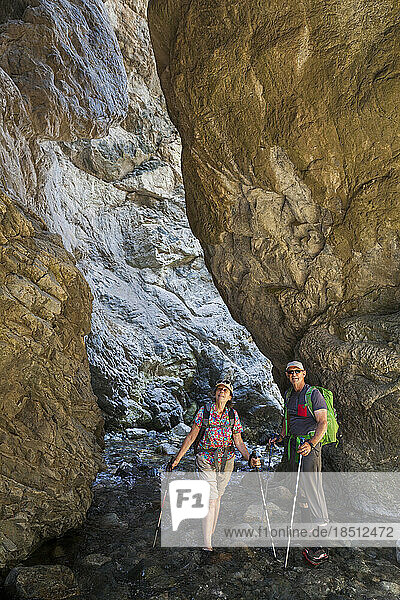 Senior couple hike into narrow canyon