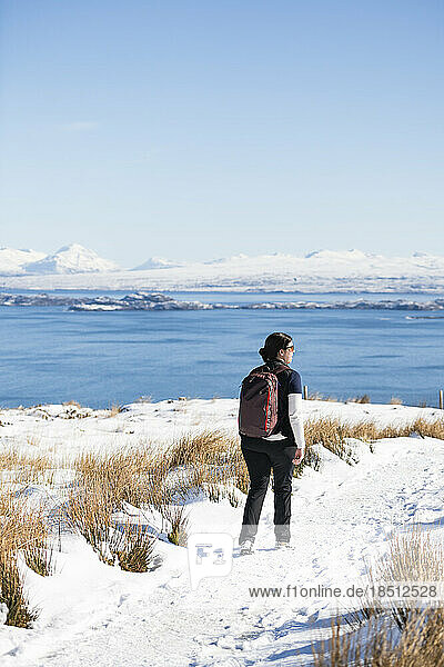 Millenial Woman hiking through snow on Isle of Skye Scottish highlands