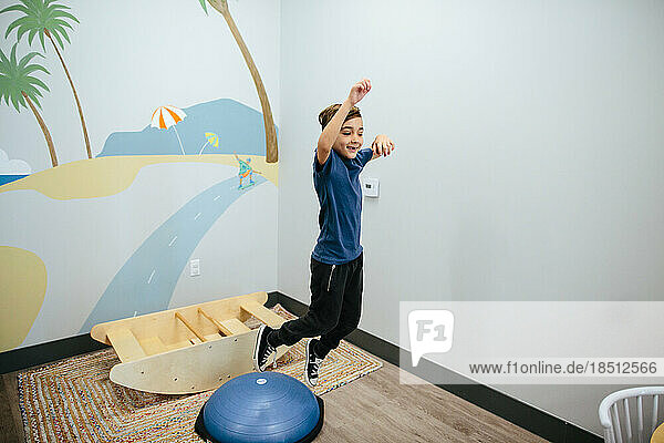 Smiling boy jumps from a sensory bouncer