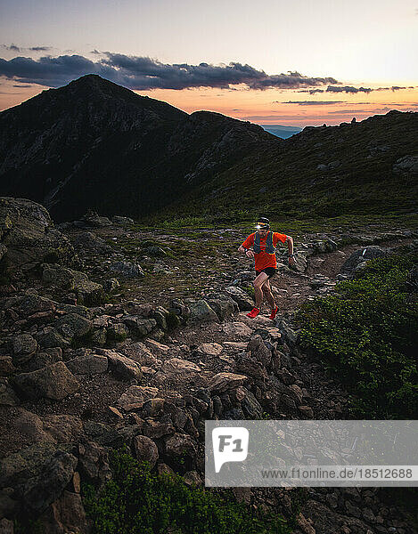 Trail runner with headlamp running on the Franconia Ridge