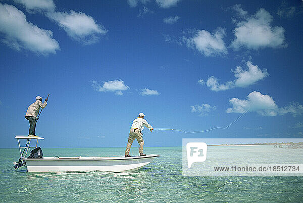 Two men fly-fish from a boat in the Bahamas.