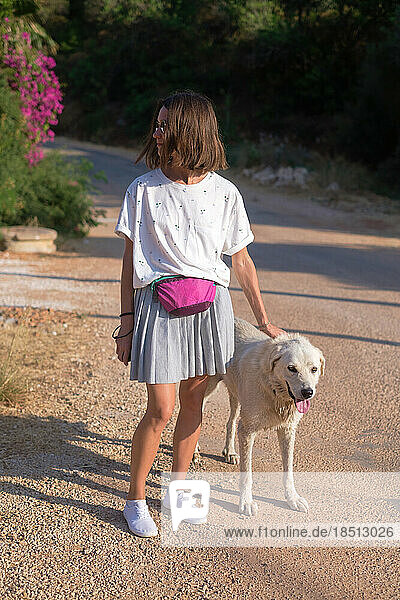 A cool looking young woman with her dog outdoor portrait