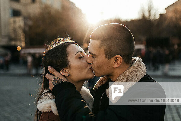 Man and woman kisses under the autumn sun in the center of Prague