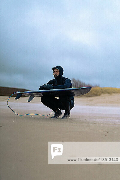 surfing in Kamchatka. Man in a wetsuit with a surfboard on the s