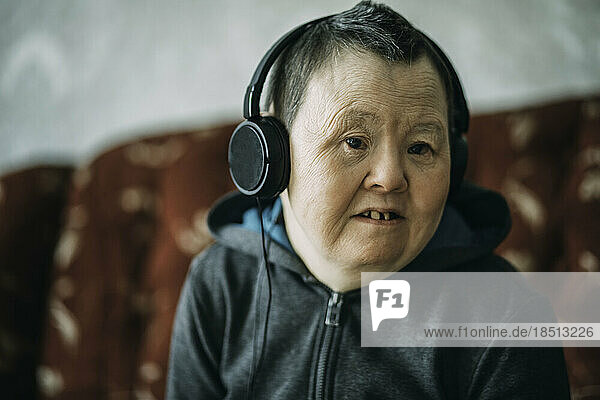 elderly woman with down syndrome wearing headphones  music