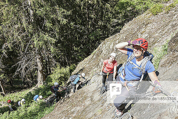 Climbing group scaling rock face via ferrata towards Stuibenfall Waterfall  Otztal  Tyrol  Austria