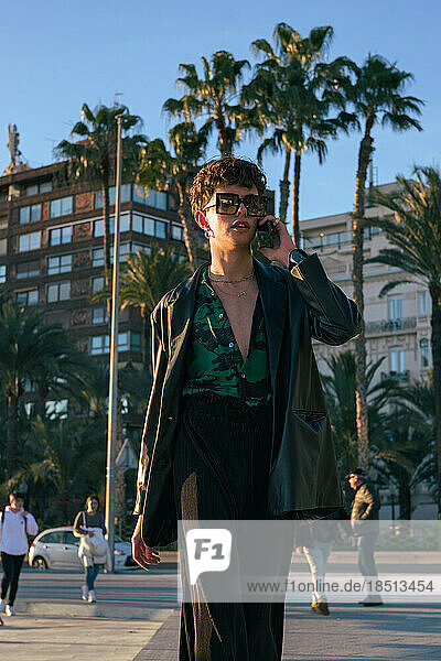 Stylish alternative man with sunglasses talks through his phone