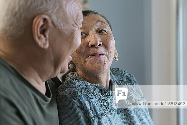 Happy senior couple at home next to the window