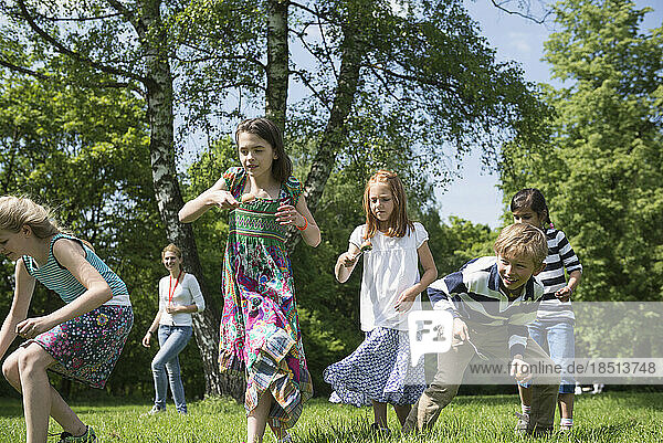 Group of children competing in an egg-and-spoon race in park  Munich  Bavaria  Germany