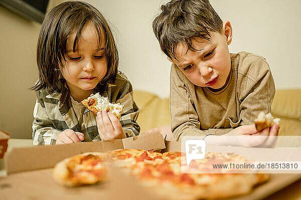 Brothers eating pizza at home