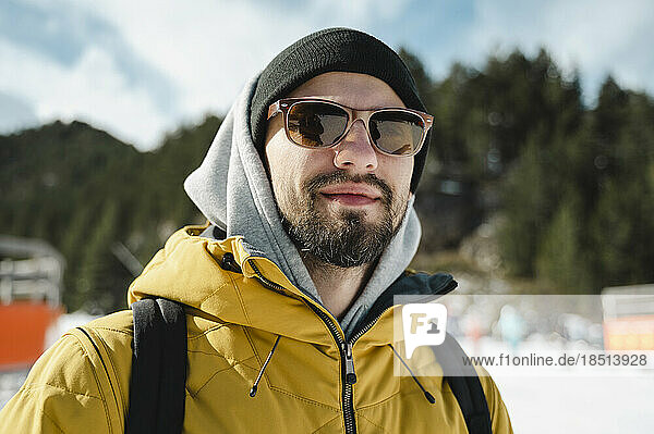 Lächelnder Mann mit Sonnenbrille im Skigebiet