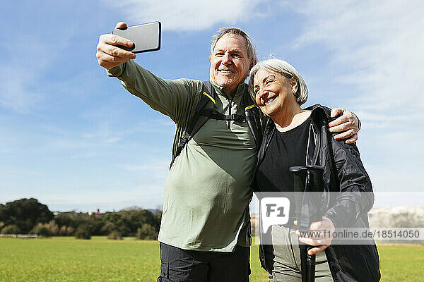 Senior man taking selfie with woman on a sunny day