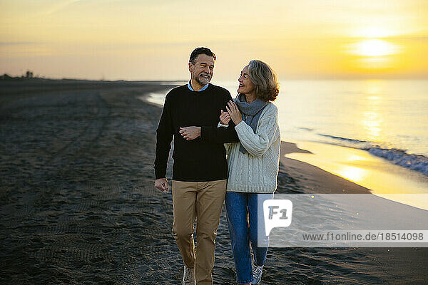 Glückliches älteres Paar  das am Strand spaziert