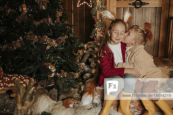 Bruder küsst Schwester zu Weihnachten auf die Wange