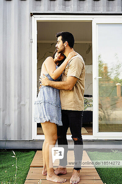 Romantic couple embracing outside container home