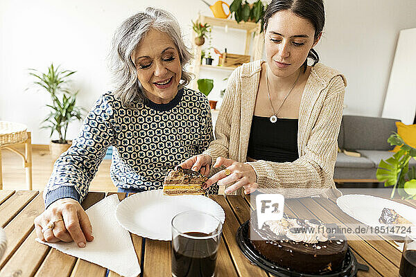 Daughter serving cake to mother at home
