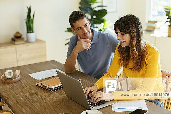 Freelancing couple working together at table in home office