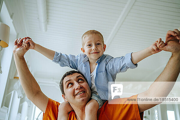 Glücklicher Vater trägt seinen Sohn zu Hause auf den Schultern