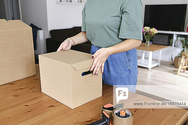 Young woman packing order at home